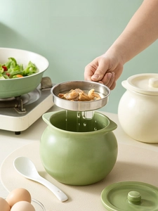Detail of light green ceramic oil pot featuring dual handles and 304 stainless steel mesh filter