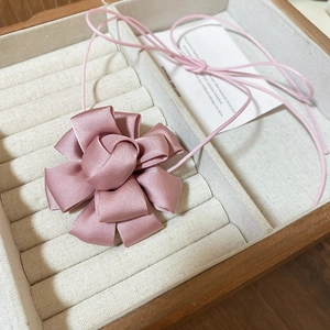 Elegant pink satin ribbon flower choker necklace displayed in a premium jewelry box