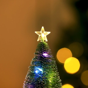 Macro view of a mini Christmas tree featuring glowing LED stars and festive lighting