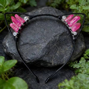 Macro view of pink crystal cat ear headband handcrafted on a dark grey natural rock