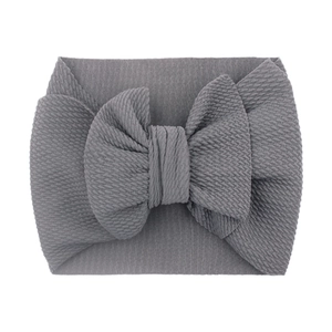 Detail of grey textured fabric baby headband featuring a large soft decorative bow