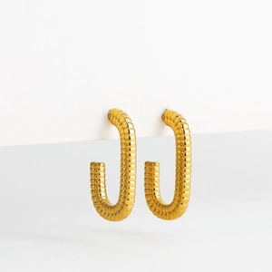 Macro shot of 18K gold plated rectangular earrings with textured geometric patterns