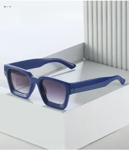 Vista macro di montature blu spesse e lenti viola sfumate su espositore minimalista