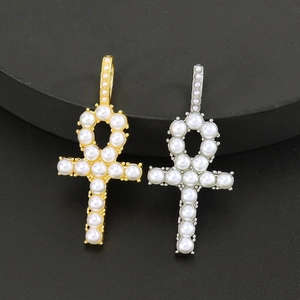 Luxurious gold and silver Ankh cross pendants with inlaid pearls on a black display stand
