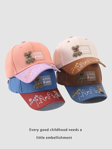 Detail of four colorful cotton baby baseball caps featuring cartoon bear embroidery