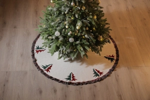 Detail of knitted Christmas tree skirt with festive cedar patterns and dark fringe