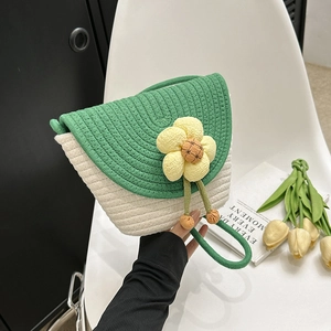 Detail view of handmade woven bucket bag with green lid and large floral ornament