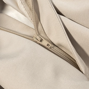 Close-up of invisible zipper and twill cotton fabric on beige short jacket for women