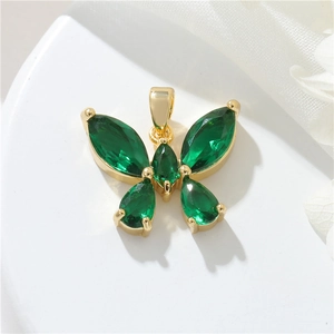 Exquisite 14k gold butterfly pendant with emerald zircon crystals on white tray