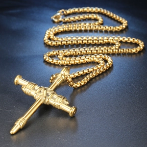 Gros plan détaillé du pendentif croix clou en acier titane doré sur une chaîne maille
