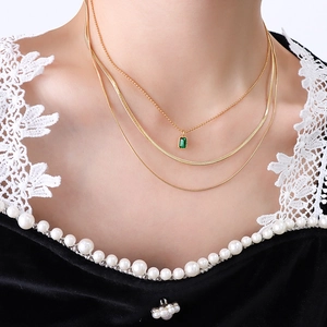 Three-layer 18k gold plated necklace with emerald-cut green zircon on a model