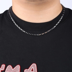Silver stainless steel chain necklace with tiny foot charms on a model neck