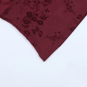 Détail du tissu en maille bordeaux avec flocage floral et coutures d'ourlet impeccables