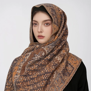Close-up of winter thick scarf with paisley pattern and gold trim in hijab style
