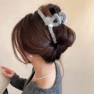 Detailansicht einer grauen Plüsch-Haarklammer mit Perlen auf einer eleganten Hochsteckfrisur