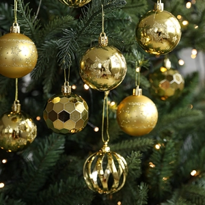 Golden Christmas ball ornaments set with glitter and geometric textures on green tree