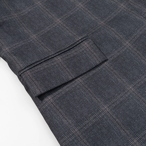 Dettaglio di blazer grigio a quadri con gessato rosa e tasca con patta cucita