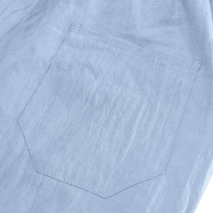 Close-up of the front pocket on a light blue linen shirt showing detailed fabric texture