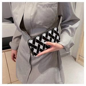 Macro detail of black and white woven pattern and silver zipper on women's long wallet