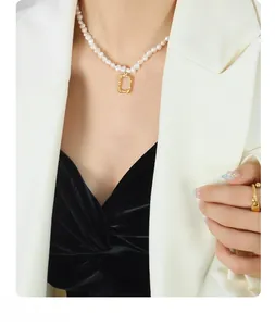 Close-up of elegant gold wave pendant with freshwater pearls on a model