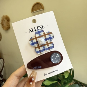 Detail of blue floral pearl BB clip and brown polka dot hair clip on display card