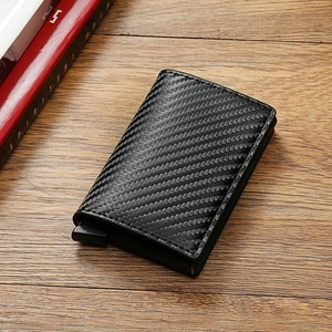 Detail view of carbon fiber RFID card holder with automatic pop-up lever on wood desk