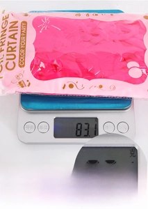 Macro shot of 83.1g rose pink fringe curtain in retail packaging on a digital scale