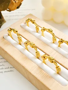 Détail de bagues en acier titane doré mat noué avec bougies et livres de style