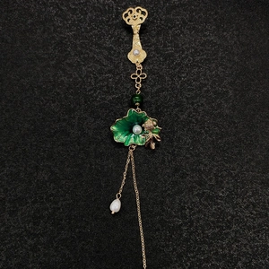 Détail de la broche chinoise avec perles, lotus en émail vert et franges dorées