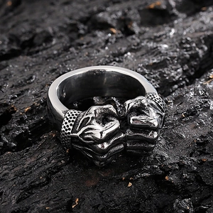 Close-up of vintage silver double fist ring for men on a black textured background