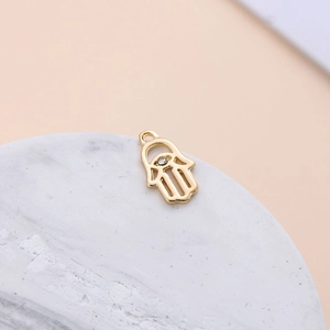 Macro view of gold Hamsa hand pendant with inlaid crystal for DIY jewelry making