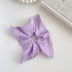 Close-up of purple satin silk scrunchie with square scarf design on white tabletop