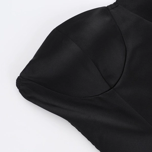 Detailed macro view showing the glossy black satin fabric and ruched bodice stitching