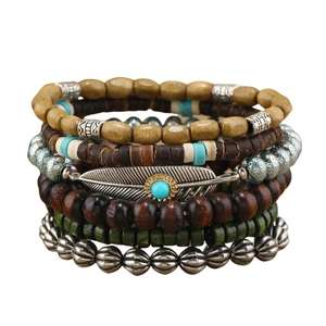 Detail of multi-layer beaded bracelet set with turquoise accents and feather charm