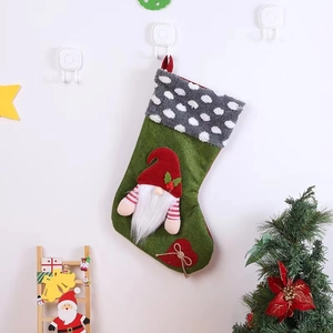 Détail de chaussette de Noël verte avec un gnome sans visage et un patch en cœur rouge
