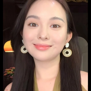 Gros plan de boucles d'oreilles en raphia doré portées par un mannequin chic