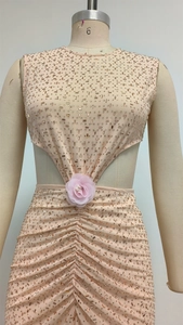 Détail de la taille évidée avec fleur rose et strass sur la robe de soirée sans manches