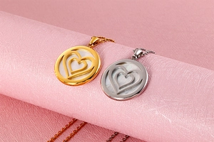 Detail of gold and silver double-layered heart pendants in circular stainless steel charms