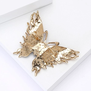 Detailed back view of the golden enamel butterfly brooch showing the metal pin fastener
