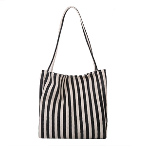 Minimalist canvas tote bag featuring black and white vertical stripes and long straps