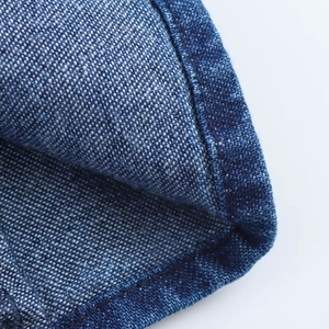 Dettaglio ravvicinato della trama denim blu scuro e delle cuciture di qualità sul vestito