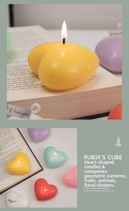 Close-up of heart-shaped scented candles in multiple colors on retro book background