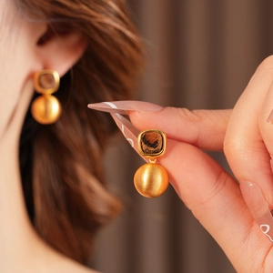 Detailed view of French vintage gold round earrings with brown leopard print and studs