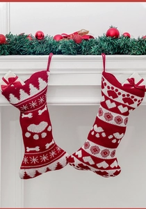 Close-up of red and white knitted bone-shaped Christmas stockings with paw prints