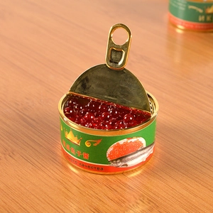 Macro shot of miniature red caviar tin with golden metal lid and detailed label