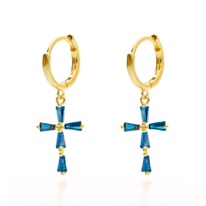 Golden hoop earrings with blue crystal cross pendants on a white reflective surface