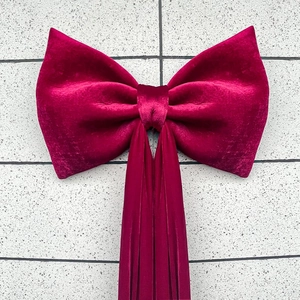 Detailed view of a large red velvet bow for wedding and holiday wall decoration