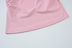 Gros plan sur tissu en maille rose élastique montrant les coutures et détails froncés