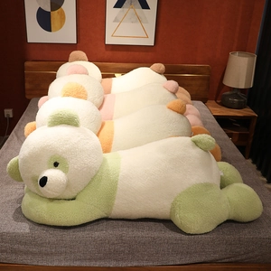 Vue détaillée de longs oreillers panda en peluche colorés dans une chambre douillette