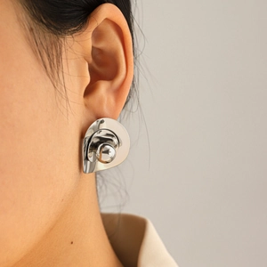 Close-up of minimalist irregular oval stainless steel stud earring on ear